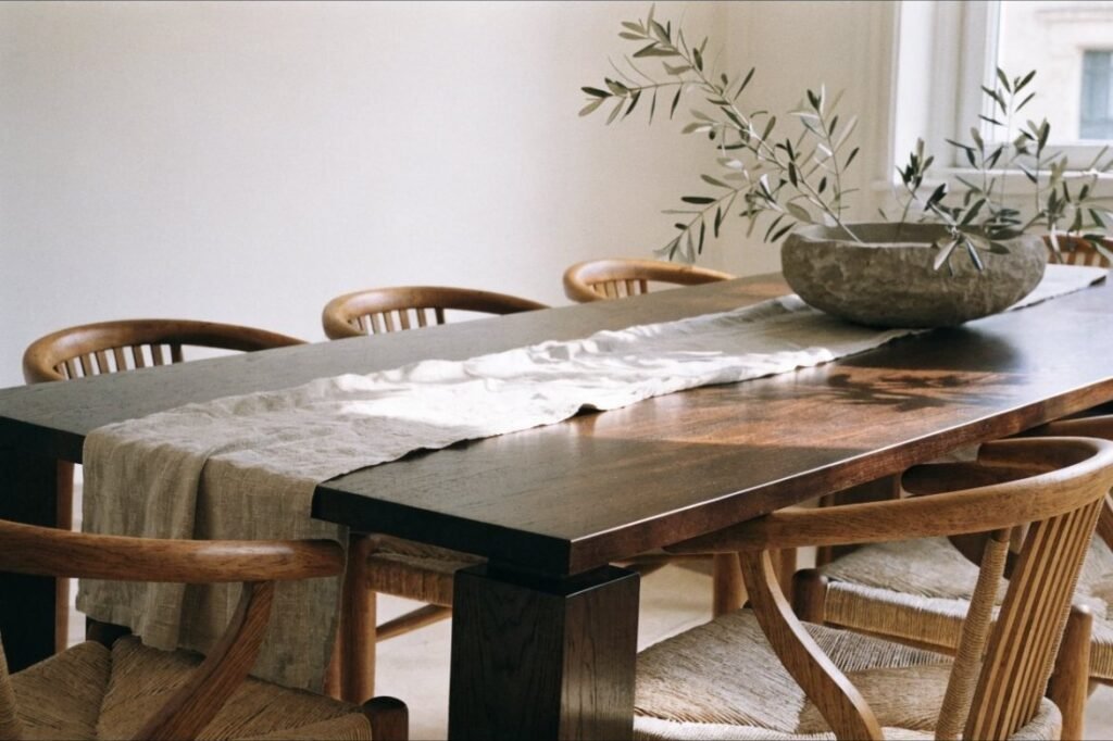 Woven rush-back dining chairs with oak frames around a rectangular walnut dining table