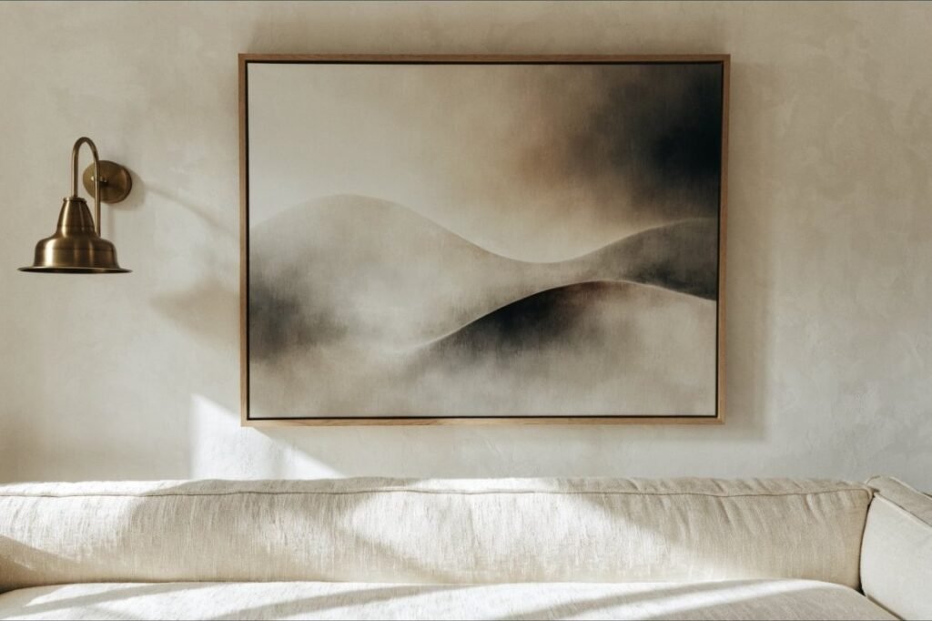 A large framed neutral abstract in a slim oak frame hung above a cream sofa