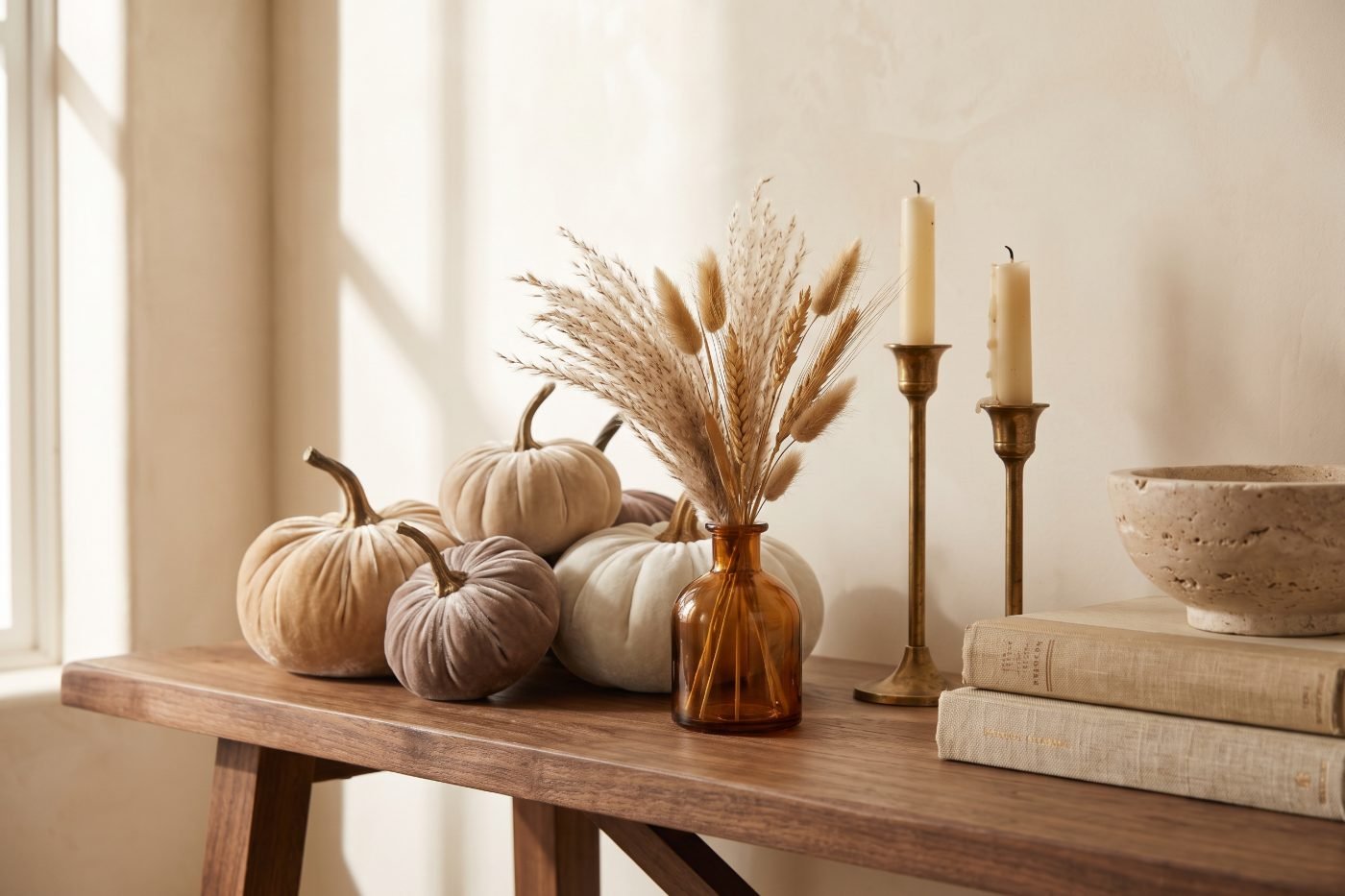 Console styled with champagne velvet pumpkins, dried pampas in an amber bud vase and aged brass candlesticks.