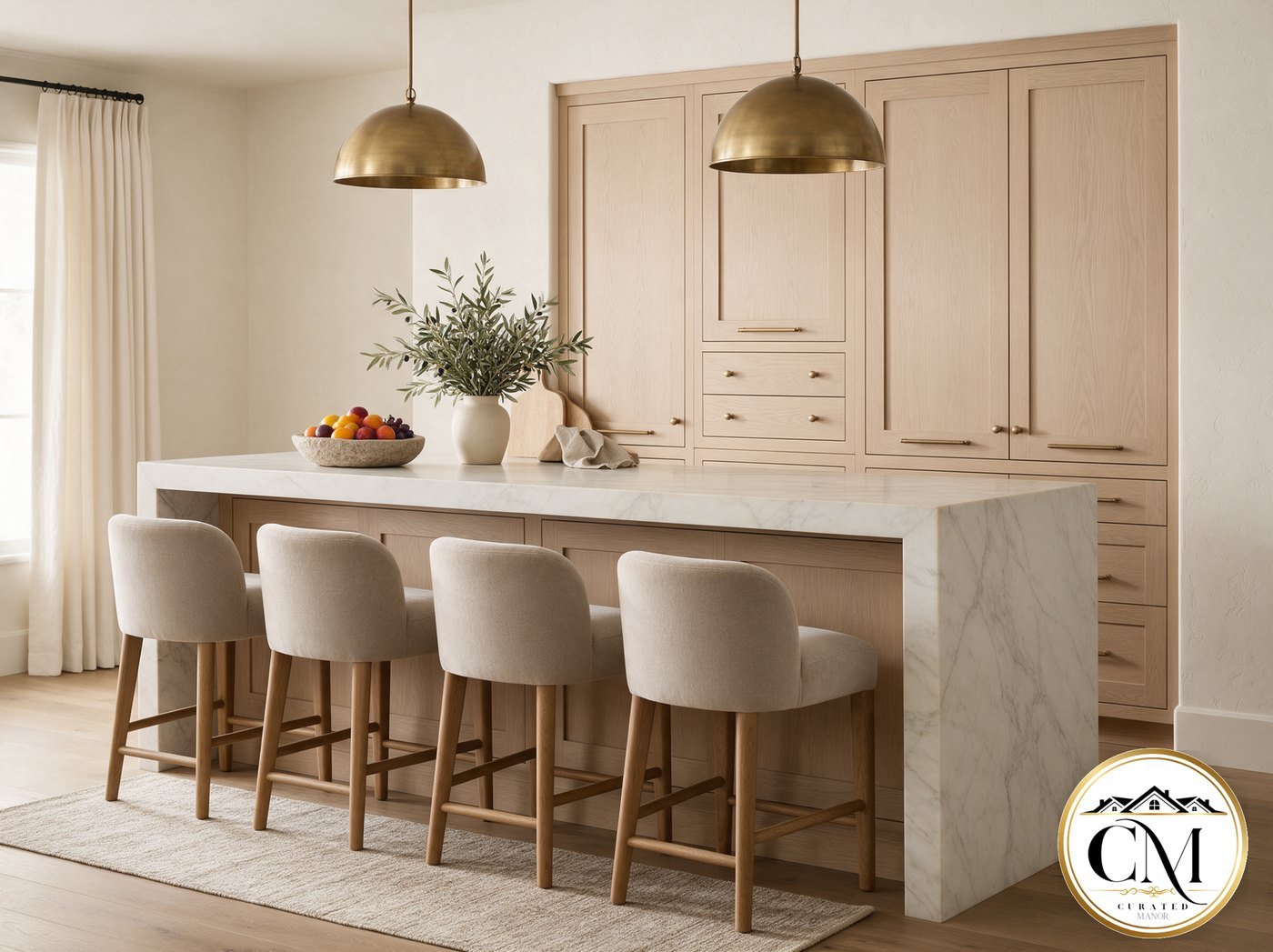 Finished designer kitchen with a white-oak island, marble waterfall counter, upholstered counter stools and brass dome pendants.